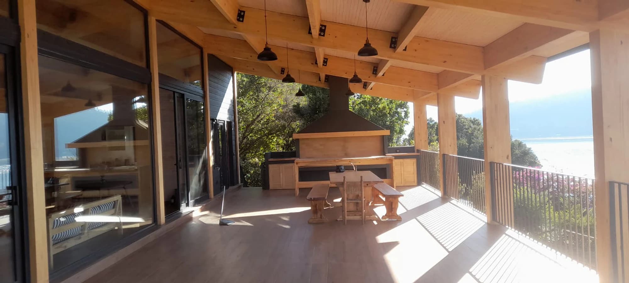 Quincho de madera abierto hacia el lago